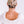 Person with styled hair and a white blouse on a light background