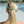 Person with blonde hair tied back with a green hair tie, standing by a pool.