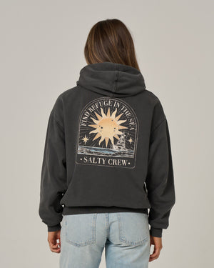 A woman viewed from the back wearing a dark charcoal gray hoodie with a large graphic print on the back. The graphic features a sun, stars, and the text 'IN REFUGE IN THE SKY' and 'SALTY CREW'.